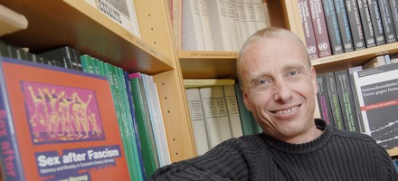 portrait de Thierry Delessert, livres, bibliothèque, sourire, cheveux blonds