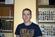 Raphaël, étudiant, t-shirt bleu marine, livres, bibliothèque